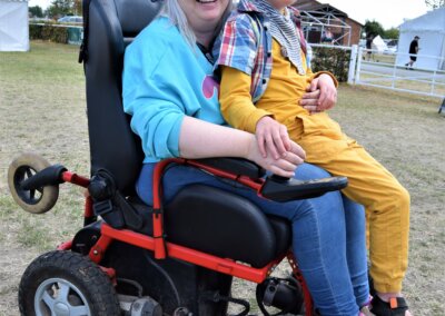 Woman in a wheelchair holding a young boy on her knee