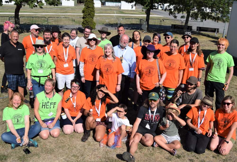 Photo of large group of people wearing orange or green t-shirts featuring the HEFF slogan