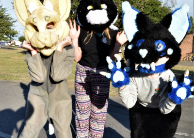 Photo of three people in furry costumes with giant heads