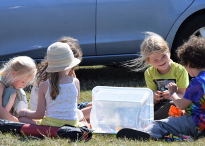 Photo of five young children playing lego on the grass