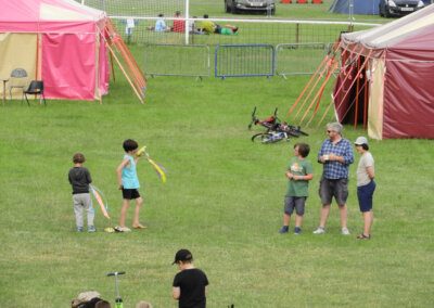 Wide shot photo of people in a field learning how to juggle