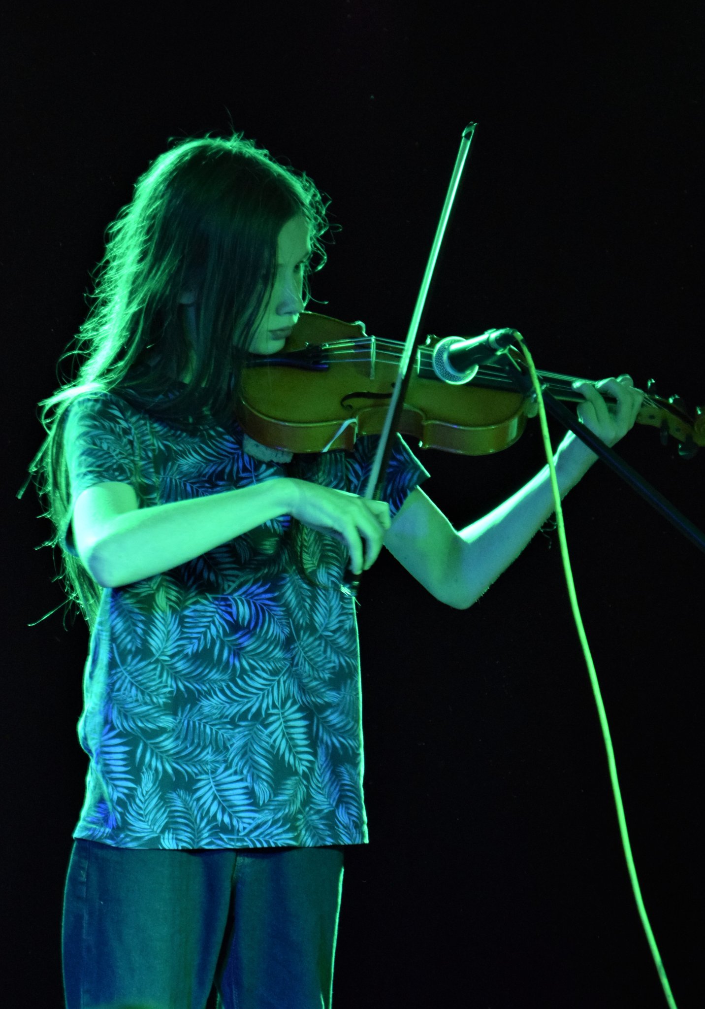 Photo of a young person playing a violin on stage