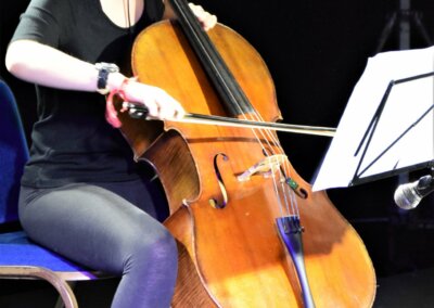 Photo of a young person playing an cello on stage