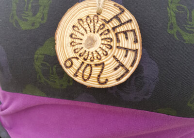 Close up photo of a wooden disc with a design on it made by a pyrography tool