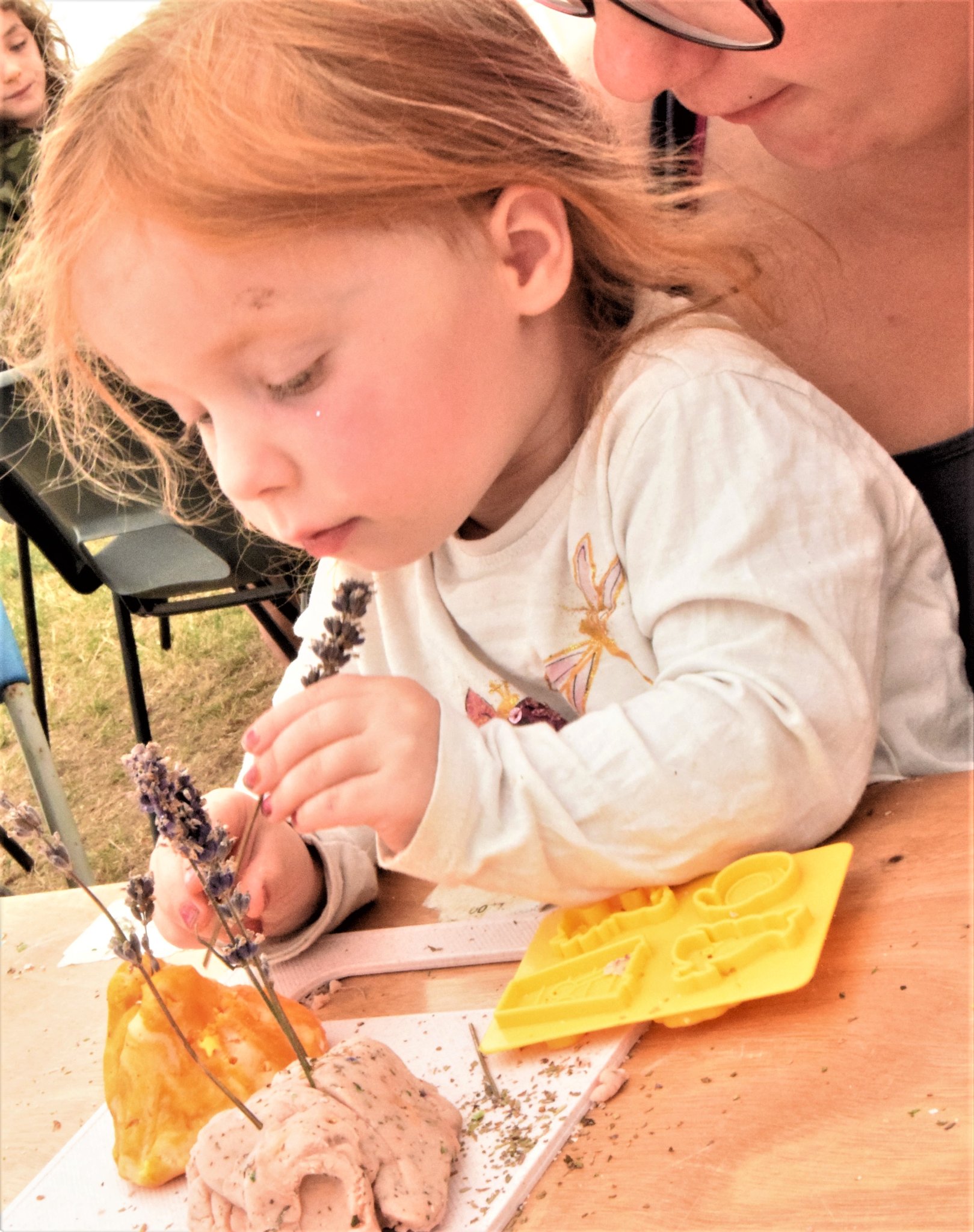 Photo of a young girl playing with play dough scented with lavender