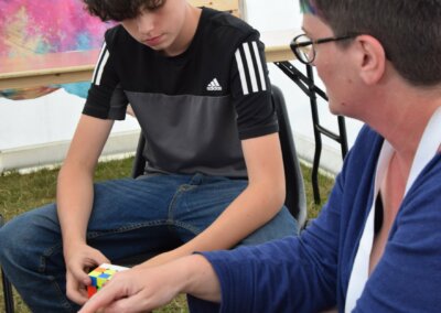 Photo of a woman demonstrating to a young person how to do a Rubik's Cube