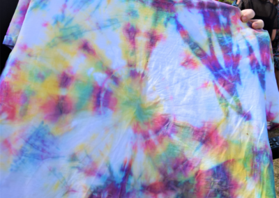 Photo of a woman holding up a tie dyed tshirt