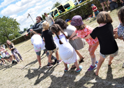 Group of young people playing tug of war in a field