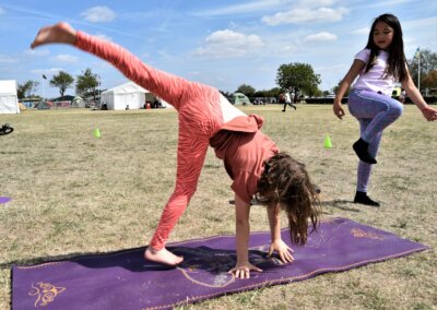 Photo of two young people doing yoga in a field